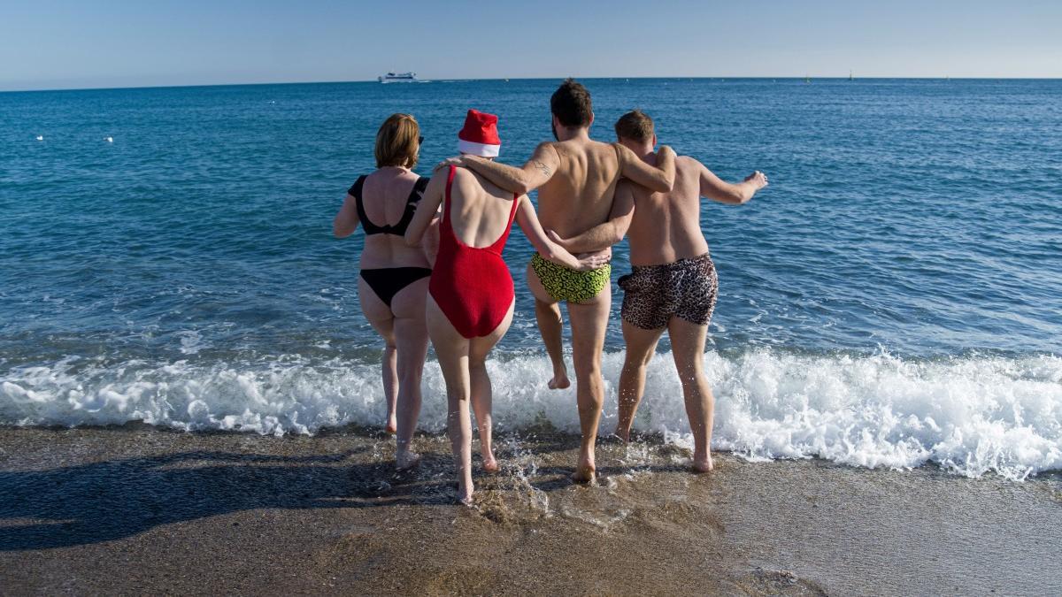 Jóvenes bañándose en la playa