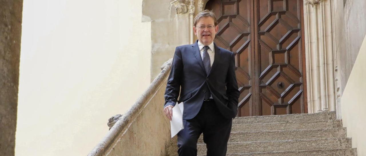 El presidente de la Generalitat, Ximo Puig, baja ayer las escaleras del patio gótico del Palau tras la conferencia virtual de presidentes.