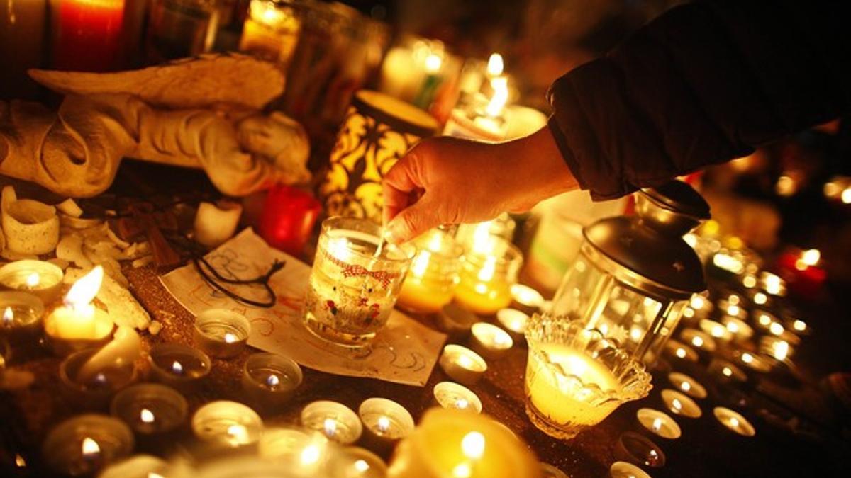 Un hombre enciende una vela en memoria de los niños y las mujeres fallecidos en la escuela de Newton.