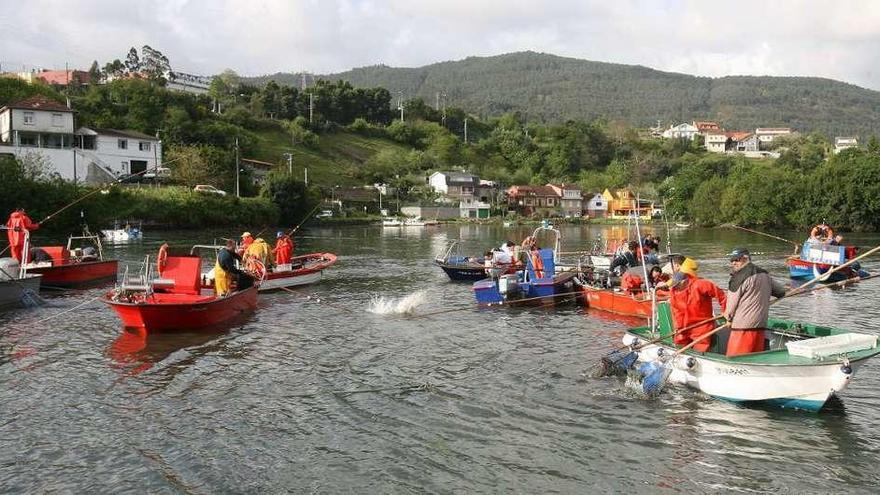 Unos mariscadores a flote extraen almeja en los bancos del interior de la ría de Vigo. // FdV