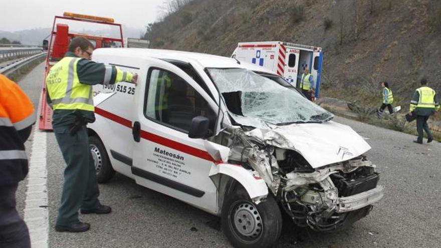 Un agente abre el furgón implicado en el choque en la Autovía Minera.