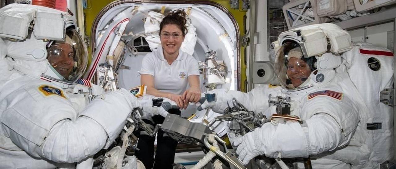 La astronauta de la NASA Christina Koch (centro) asiste a sus compañeros astronautas Nick Hague (izquierda) y Anne McClain en sus trajes espaciales de los EE. UU.