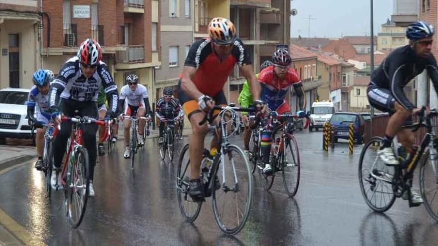 La lluvia sorprendió a los ciclistas en el último tramo. En la imagen, subiendo la Cuesta del Hospital mientras pedalean bajo la tormenta.
