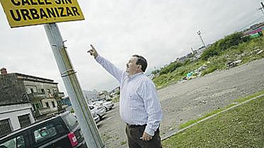 Antonio Cabrera señala el cartel de «Calle sin urbanizar».