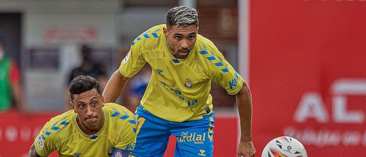 Maikel Mesa y Benito Ramírez observan el balón, con el extremo galo Haissem Hassan en el suelo del estadio de Anduva.  | | LOF