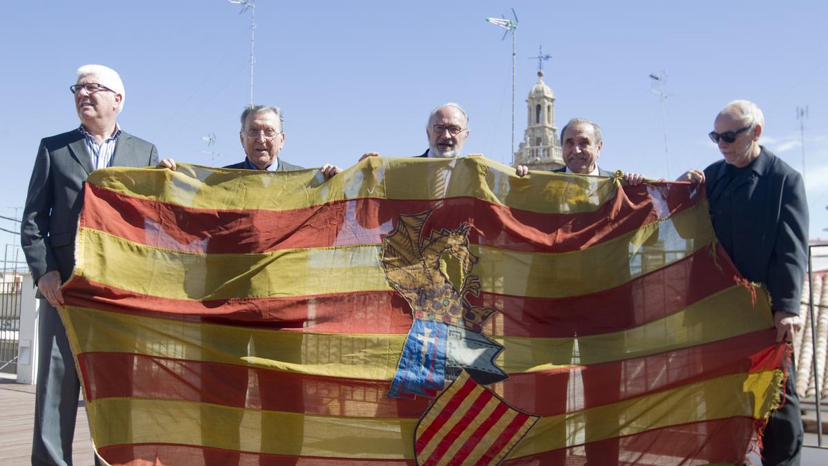 Josep Lluís Albiñana, en el centro, entrega a Eliseu Climent (4º derecha) la senyera que ondeó en el Palau de la Generalitat durante 1979, en un acto en 2014.