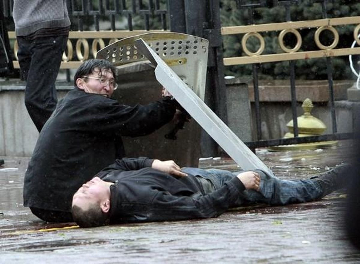 A demonstrator lies on the ground after being shot during clashes near the presidential administration in Bixkek