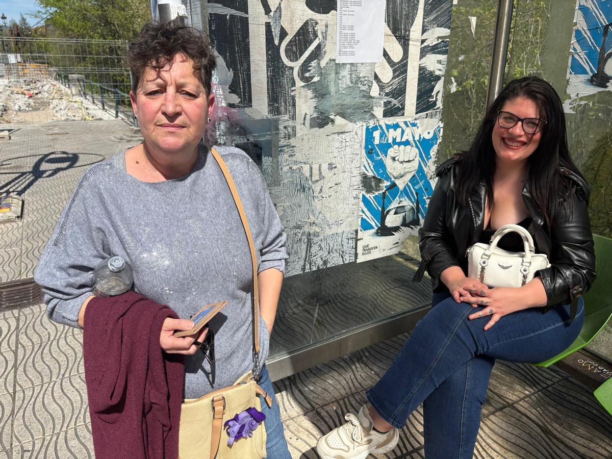 Ana González, a la izquierda, y Rubí Torres, en la parada de autobús, en Sama, durante la huelga de conductores