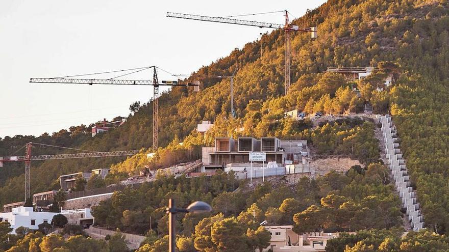 Las grúas y las nuevas viviendas en construcción en la montaña de Cas Mut junto a la escalera de acceso visible desde la ciudad.