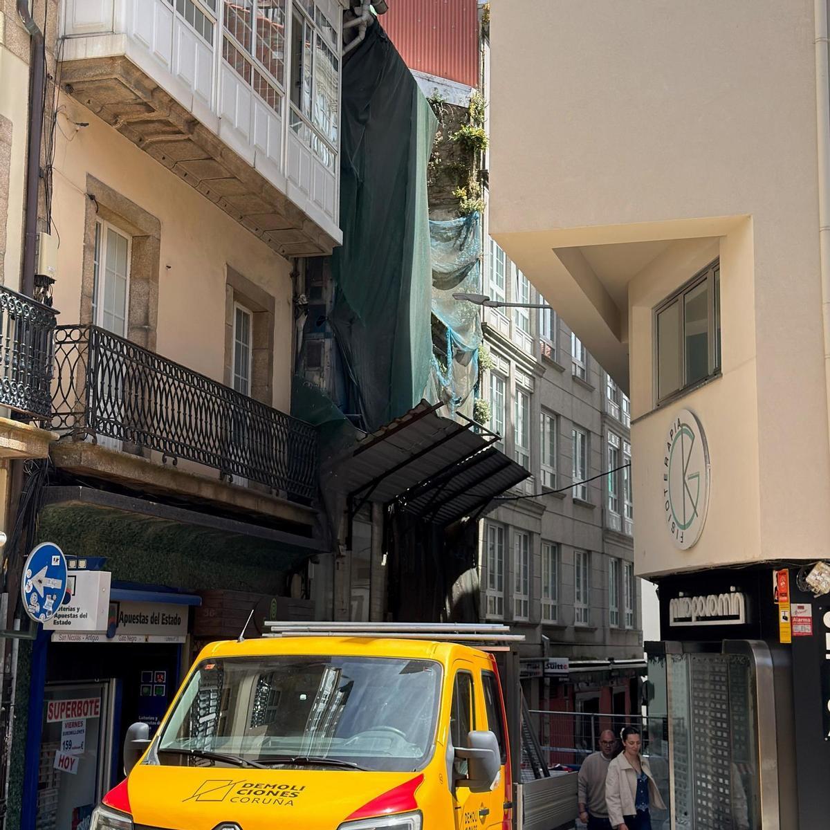 El vehículo de la empresa de demoliciones, con el edificio en ruinas detrás
