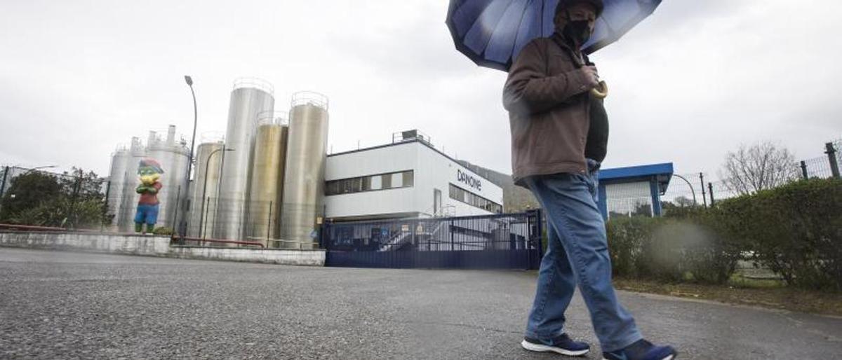 Un hombre pasea ante la fábrica de Danone en Salas. 