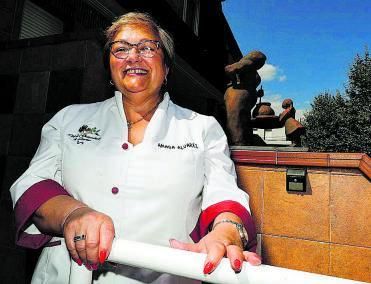 Amada Álvarez, en su casa de Oviedo, que luce en la entrada la escultura del Club de Guisanderas. | L. Murias