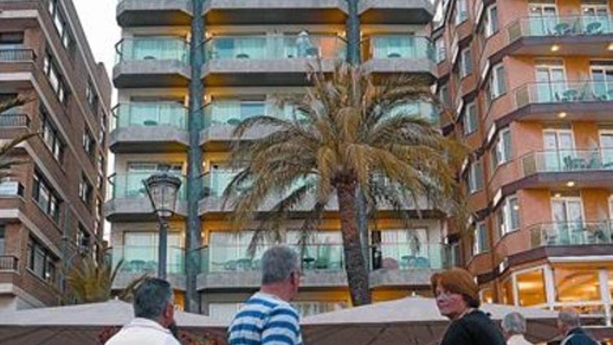 Un grupo de curiosos observa la fachada del hotel donde se cometió el doble crimen.