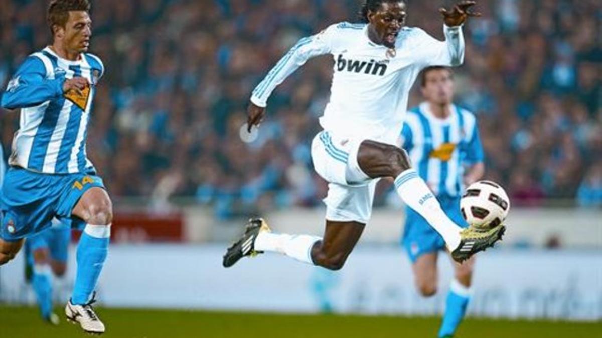 Adebayor controla la pelota ante la carrera de Galán, el joven central del Espanyol, ayer en Cornellà.