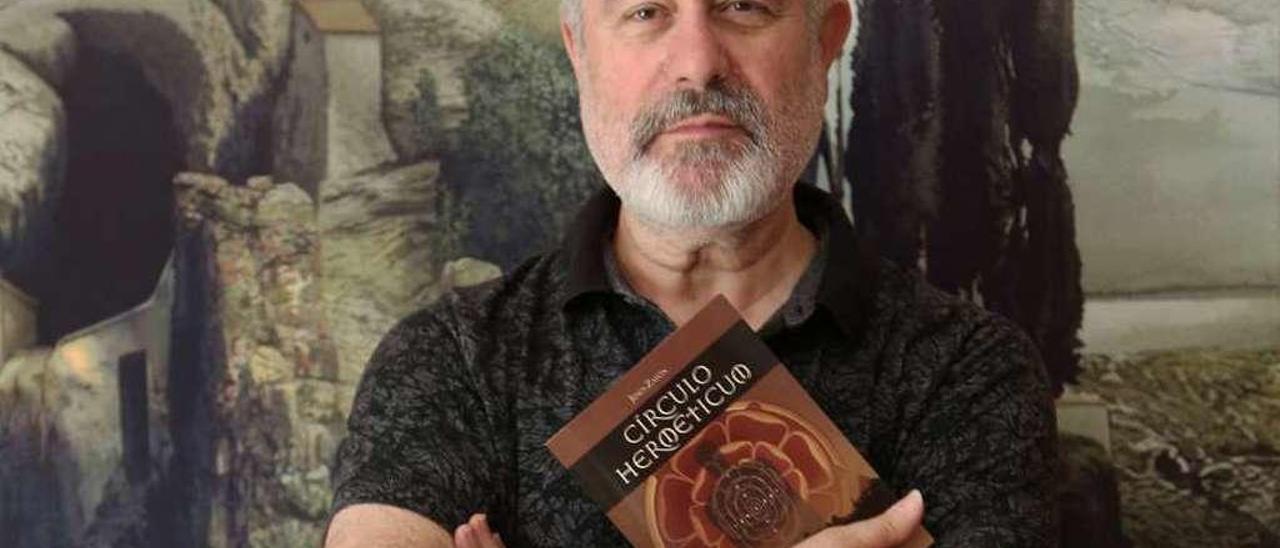 Jesús Zatón, con el libro que presenta, ante uno de sus cuadros.