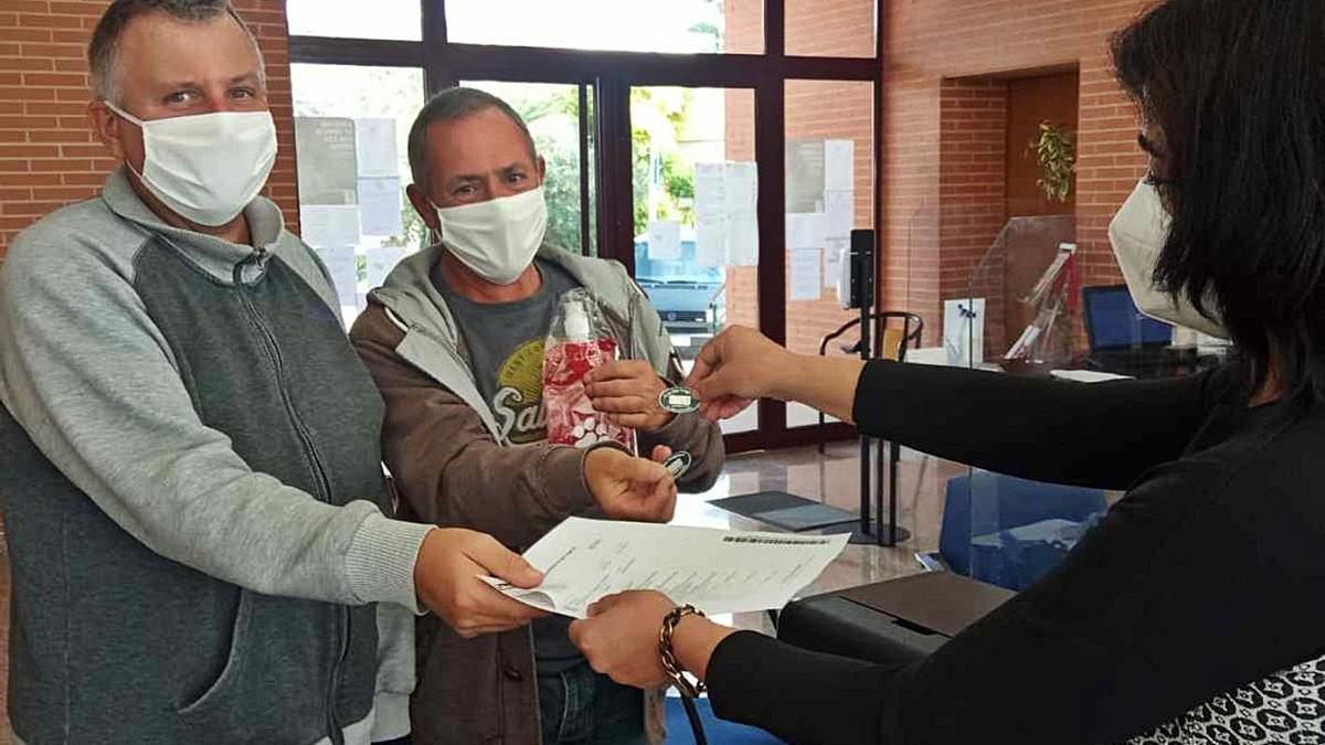 Unos vecinos de San Fulgencio reciben la chapa identificativa y un regalo al censar a sus mascotas.