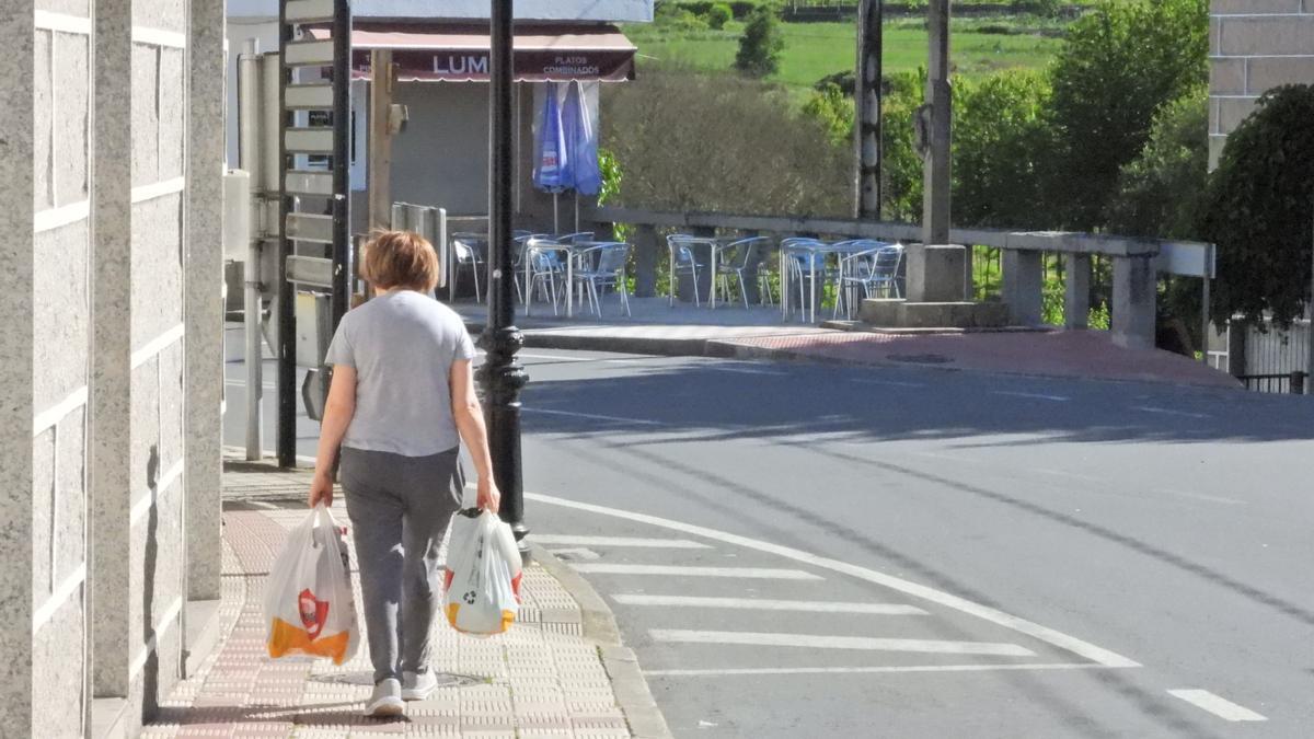 Una mujer de vuelta a casa con las bolsas de la compra.