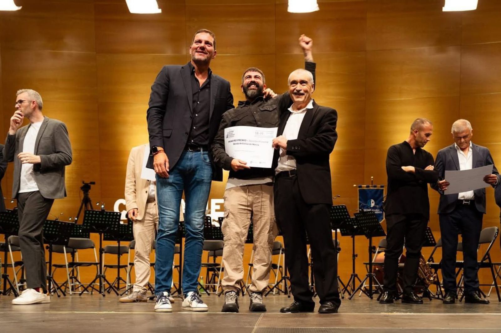 Mateo Gómez y el músico José Ramón Varela muestran el premio junto al conselleiro de Cultura.