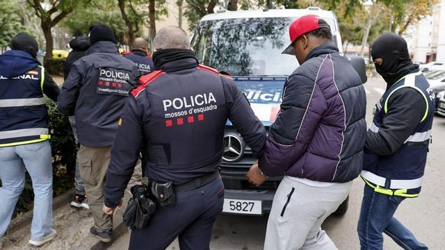 Policies custodien diversos detinguts en una operació contra els Trinitarios, implicats en robatoris violents i tràfic de drogues, el desembre passat. | TONI ALBIR / EFE