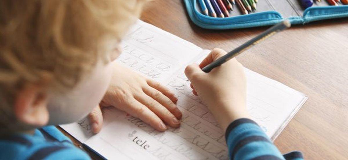 Un xiquet escriu un texte.
