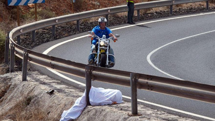 Un motorista, sobre la calzada y junto la valla, que falleció el 1 de noviembre en una vía de Antigua. i CARLOS DE SAÁ