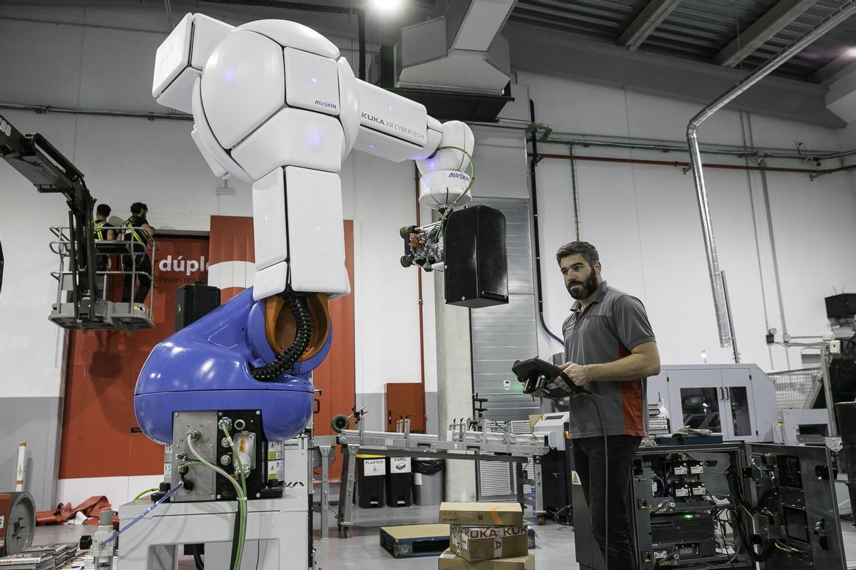 Un trabajador de Liberdúplex pone a punto uno de los robots de la nueva planta de impresión digital.