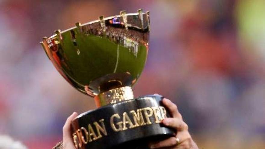 Messi levanta el trofeo de campeón del Gamper. // Efe