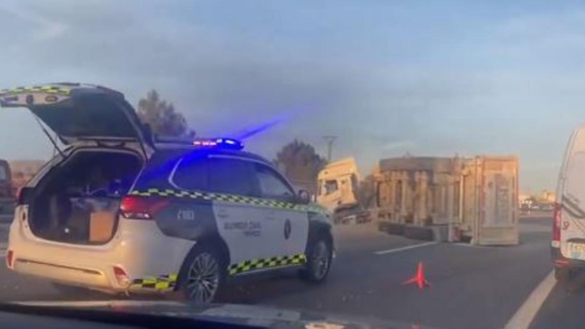 Imagen del camión volcado, captada por un conductor; al lado, un coche de la Guardia Civil.