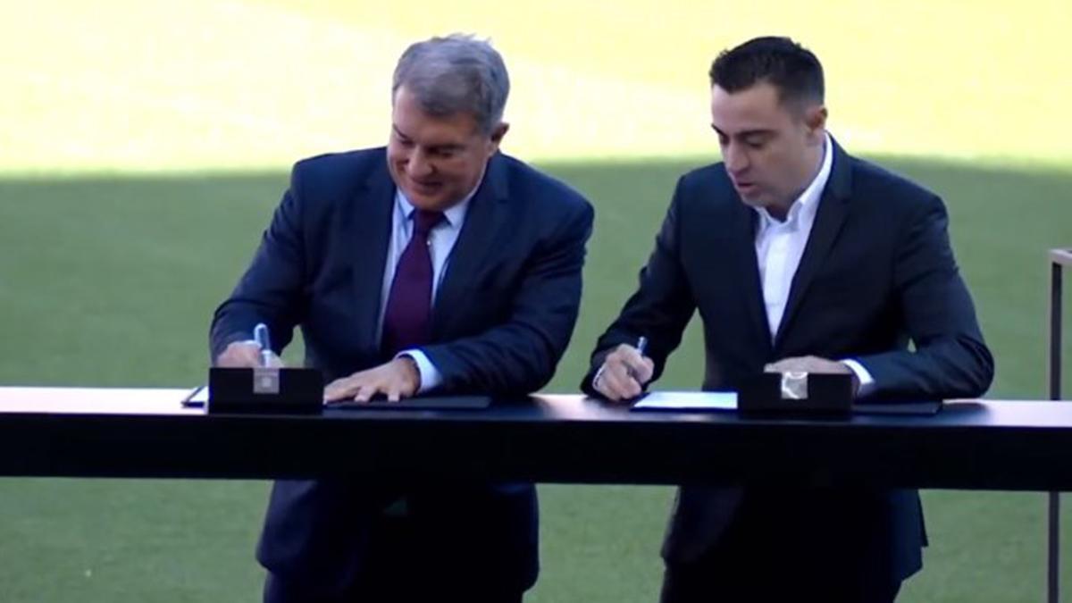 Xavi firma el contrato durante su presentación en el Camp Nou