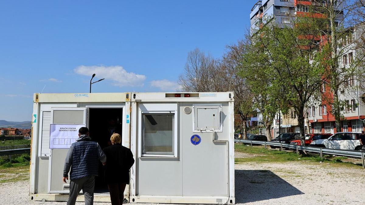 Una pareja entra en un local de votación en Mitrovica, este domingo.