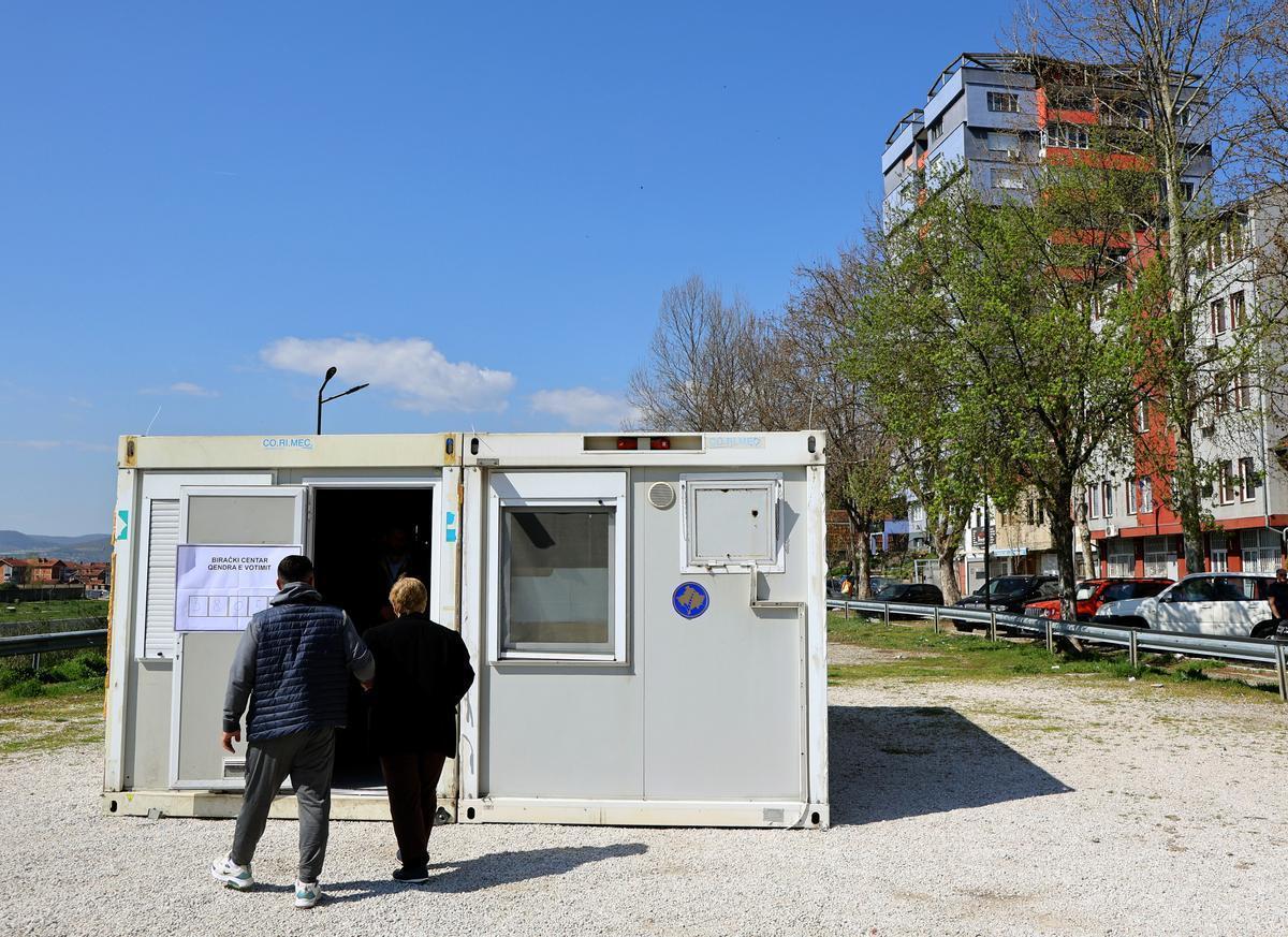 Una pareja entra en un local de votación en Mitrovica, este domingo.