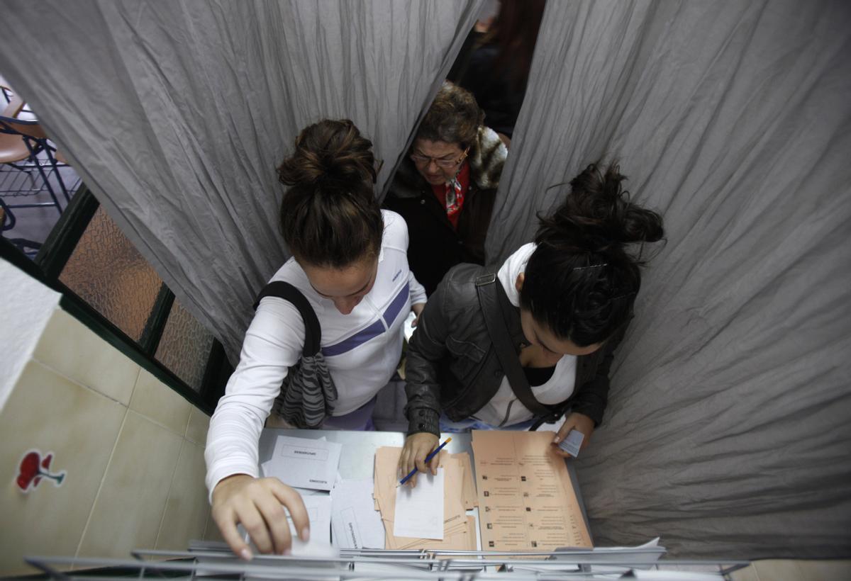 Personas eligiendo su papeleta para votar en las elecciones.