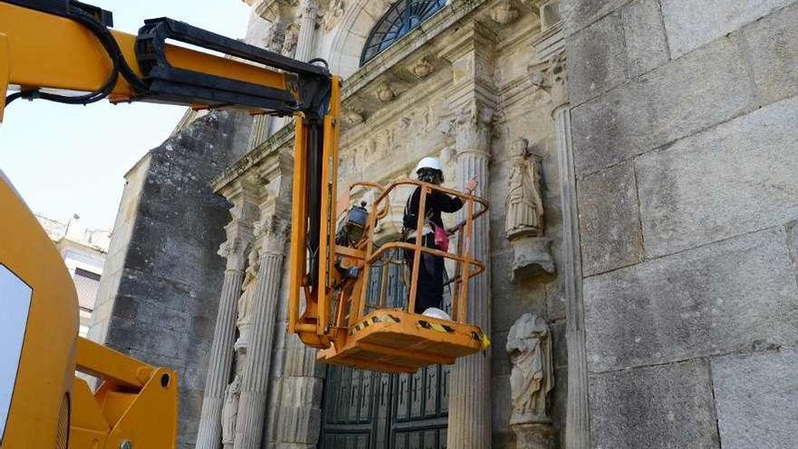 Personal técnico, evaluando ayer la fachada y las esculturas de Santiago de Cangas. // G.Núñez