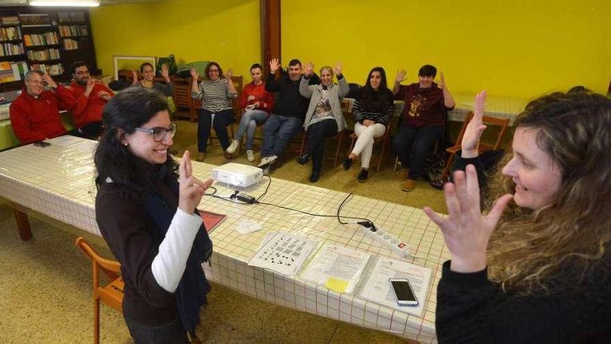 La intérprete enseña el lenguaje de signos a una catequista. // Gustavo Santos