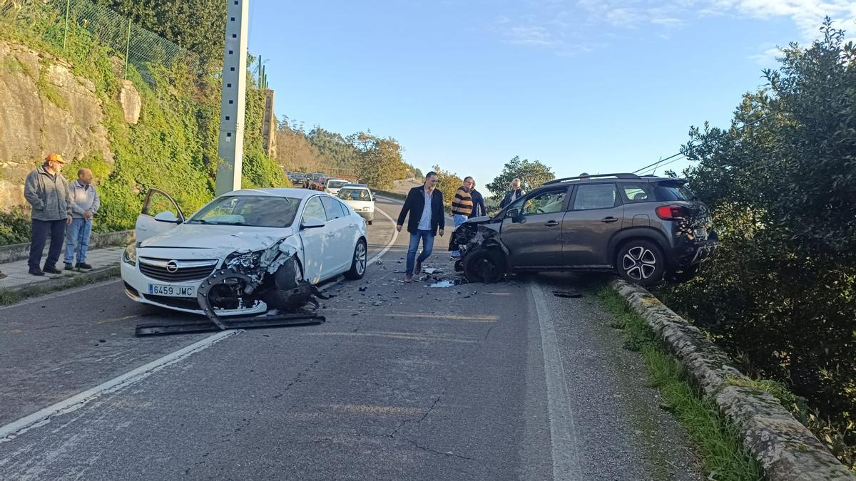 El lugar del accidente, en la PO-315 entre Cangas y Aldán, con uno de los vehículos "montado" sobre el muro lateral de protección.