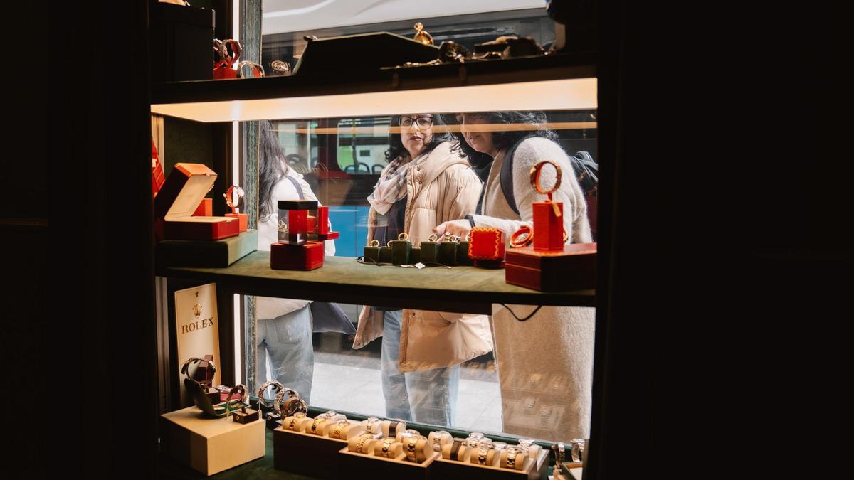 Dos mujeres observan el escaparate de una tienda.