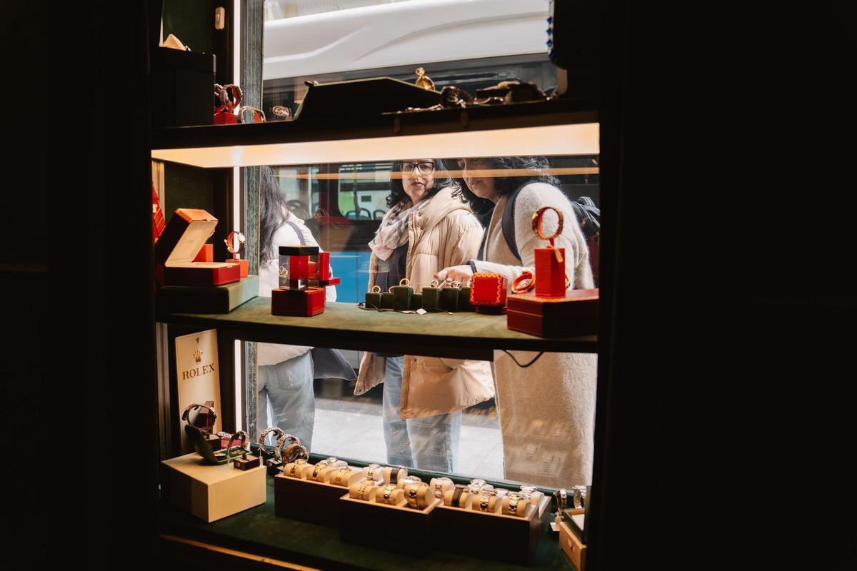 Dos mujeres observan el escaparate de la tienda de relojes de segunda mano Second Chance, en el centro de Madrid.