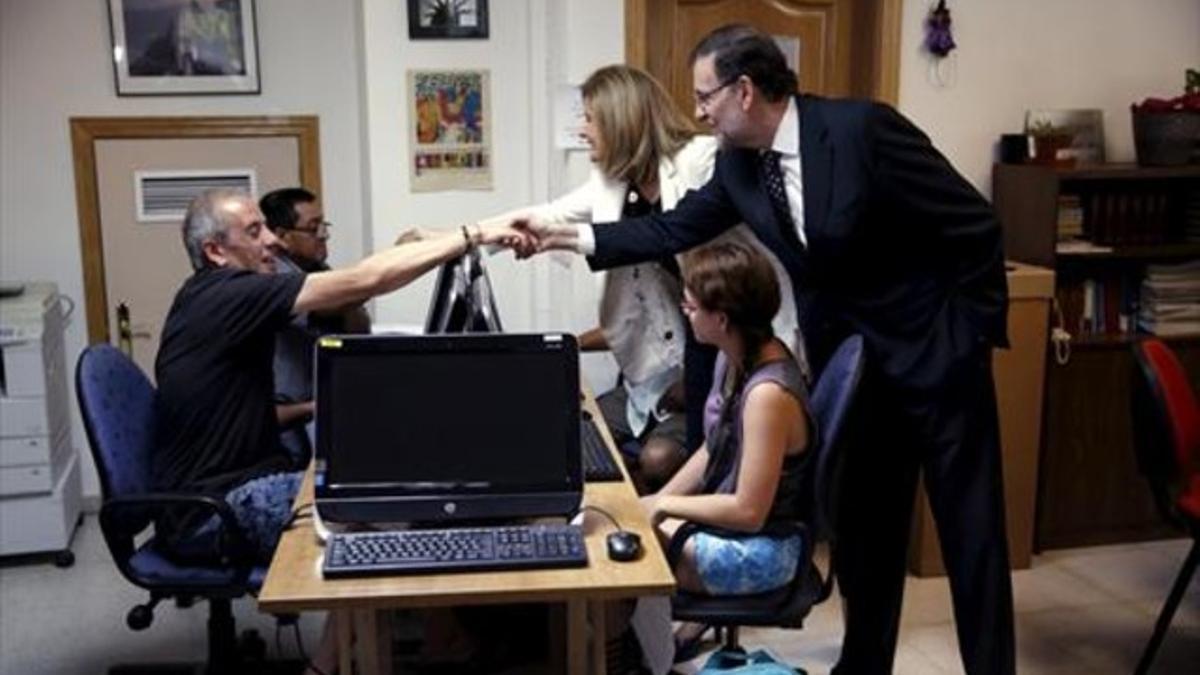 INSERCIÓN Mariano Rajoy y Fátima Báñez saludan a varios alumnos del centro de inserción laboral de la Fundación Tomillo en Madrid.