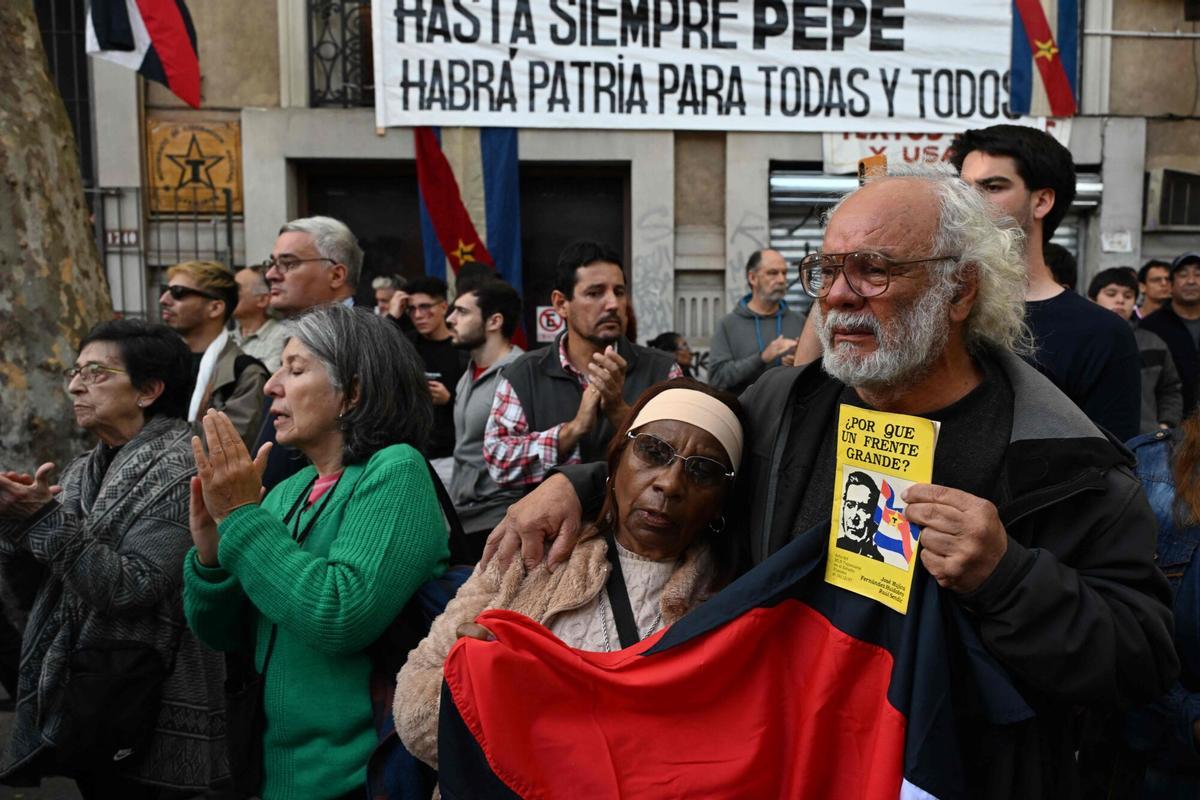 People wait for the passage of the funeral cortege of Uruguays former President Jose Pepe Mujica in downtown Montevideo, on May 14, 2025, a day after his death. Mujica, an ex-guerrilla fighter and hero of the Latin American left, died on May 13, 2025 at the age of 89. The humble leader -- who once spent a dozen years behind bars for revolutionary activity -- lost his battle against cancer after announcing in January the disease had spread and he would stop treatment. (Photo by Eitan ABRAMOVICH / AFP)