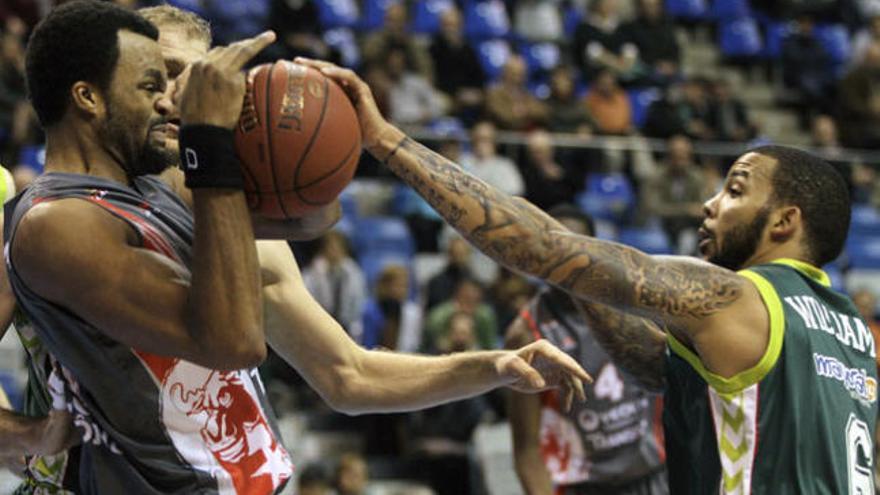 El pívot estadounidense del Elan Chalon Shelden Williams (i) lucha el balón con el base estadounidense del Unicaja Marcus Williams.