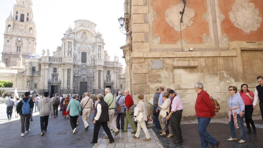 Un guía conduce a un grupo de turistas por la plaza Belluga de Murcia.
