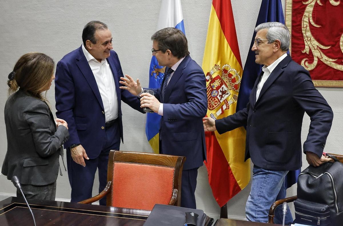 Los exconsejeros Blas Trujillo (i) y Román Rodríguez conversan con el diputado de Vox Nicasio Galván (c) antes de su comparencencia en la comisión.