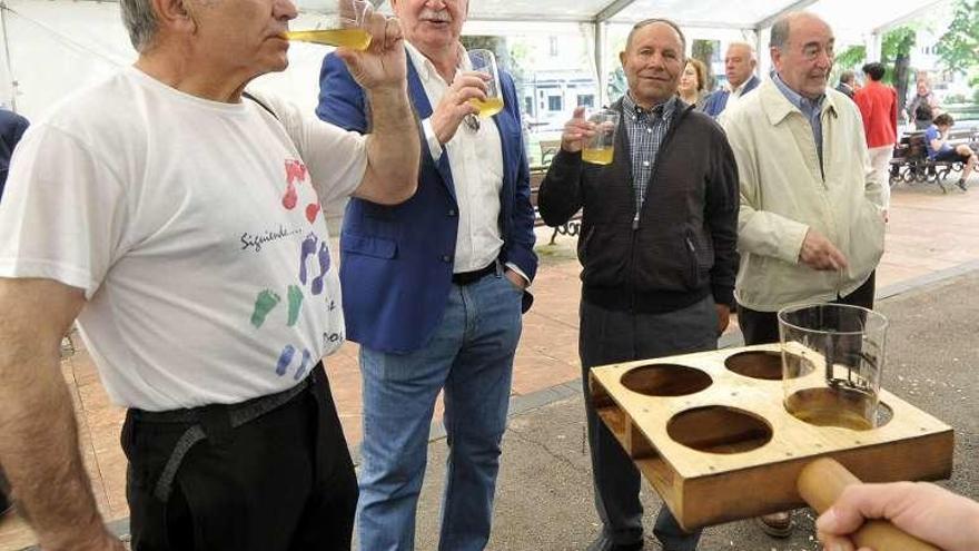 Asistentes degustando sidra de una pipa, ayer, en La Felguera.