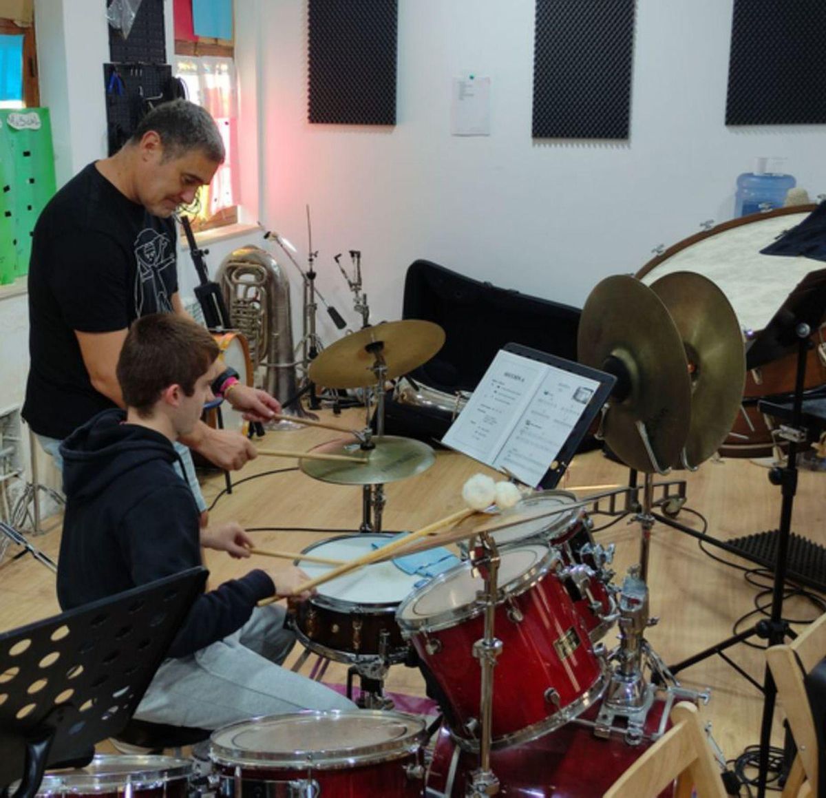 Uno de los alumnos tocando la batería, con el profesor. | E. P.