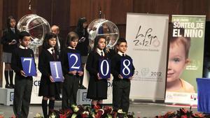 Los niños del Colegio de San Ildefonso sostienen el primer premio del sorteo de la lotería del Niño, el 71208.