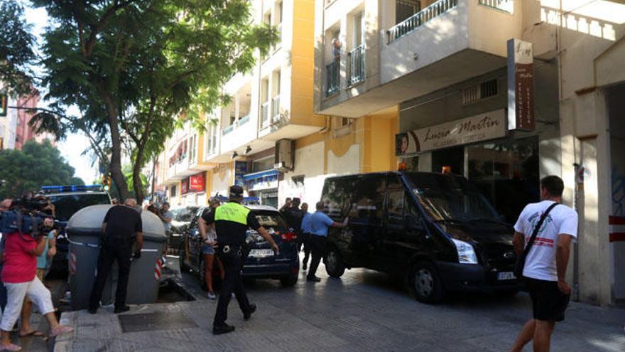 Imagen del cordón policial formado en torno al número 45 de la calle Almería, en El Palo. En la instantánea pueden ver algunas furgonetas policiales, así como el vehículo de la funeraria.