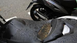 El sillín de una moto con un charco de lluvia de barro, en Barcelona.