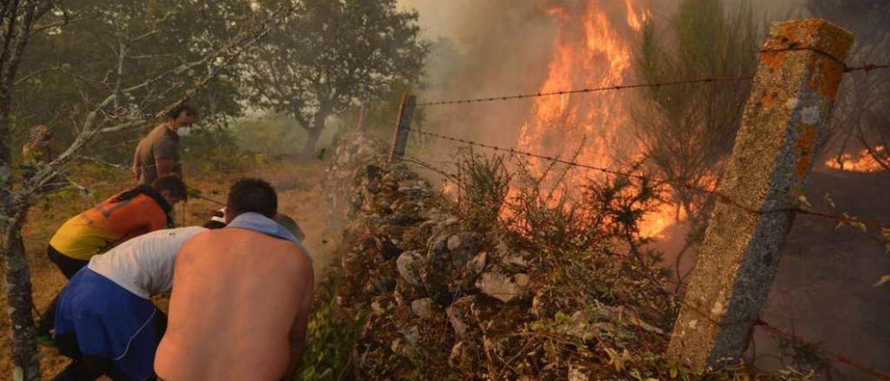 Los vecinos de Pontesampaio tratan de impedir el avance del fuego hacia la parroquia. // Gustavo Santos