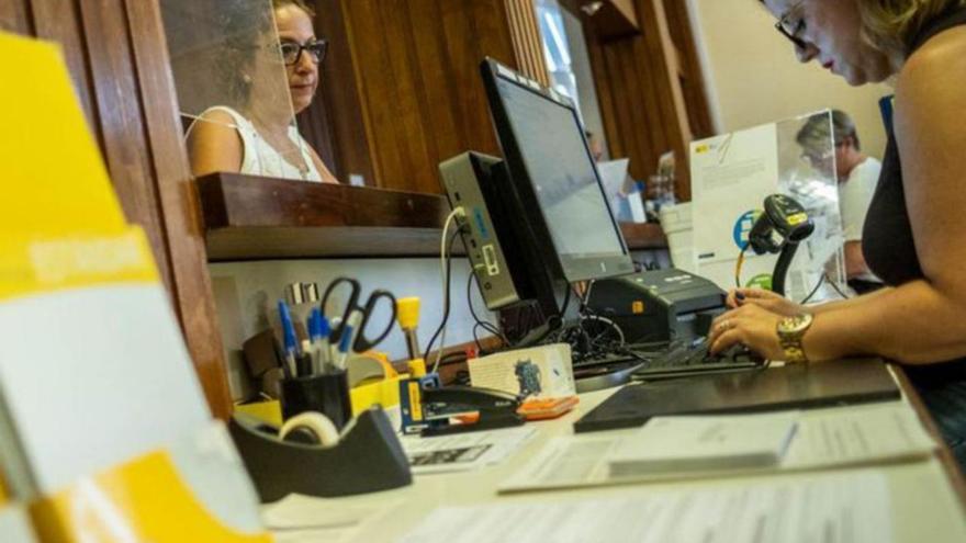 Una mujer ejerce su derecho al voto por correo en las oficinas de la Plaza de España de Santa Cruz. | | ANDRÉS GUTIÉRREZ