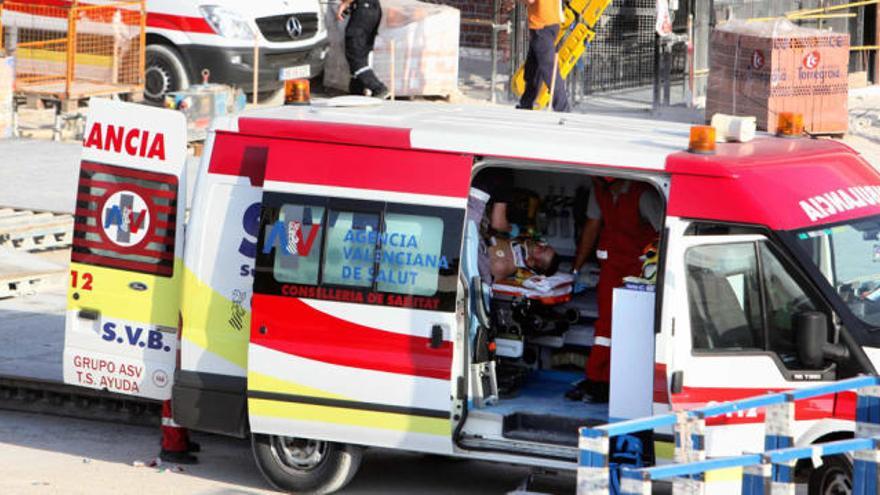 Varios sanitarios atendiendo en el interior de una ambulancia a uno de los operarios heridos en el accidente, tras ser evacuado de la zona del montacargas.